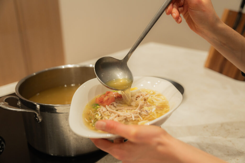 alt="Serving soto ayam during a cooking class at Dharma Resort"